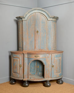 An Antique wooden corner cupboard with distressed blue paint