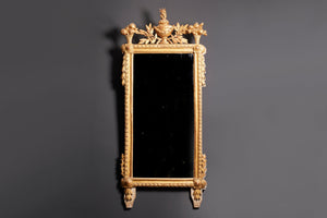 a gilt framed mirror with a carved urn and leaves
