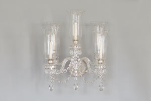 a pair of glass sconces with five lights in a glass lamp shade