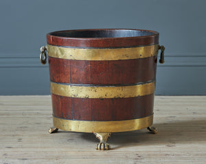 a wooden bucket with brass handles and clawed feet