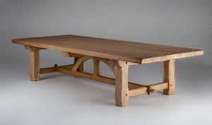 an oak dining table with a semi-circular support